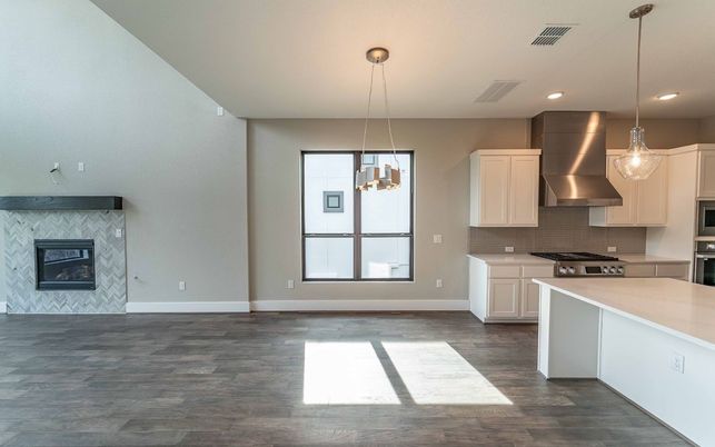 Empty room, Fireplace, Interior, Kitchen, Pendant Lights, Recessed Lighting, Stainless Steel Appliances, Wood Texture Flooring