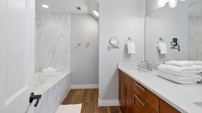 Bathroom, Dual Sink Vanities, Interior, Marble Walls, Recessed Lighting, Wood Texture Flooring