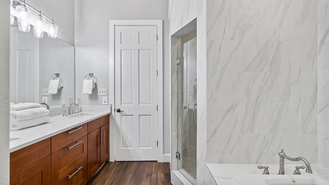 Bathroom, Dual Sink Vanities, Glass Shower, Interior, Marble Walls, Wood Texture Flooring