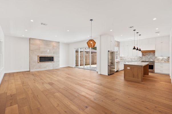 Empty room, Fireplace, Interior, Kitchen, Pendant Lights, Recessed Lighting, Stainless Steel Appliances, Wood Texture Flooring