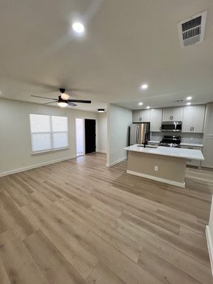 Empty room, Interior, Kitchen, Recessed Lighting, Stainless Steel Appliances, Wood Texture Flooring