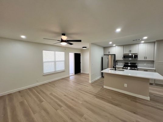 Empty room, Interior, Kitchen, Recessed Lighting, Stainless Steel Appliances, Wood Texture Flooring