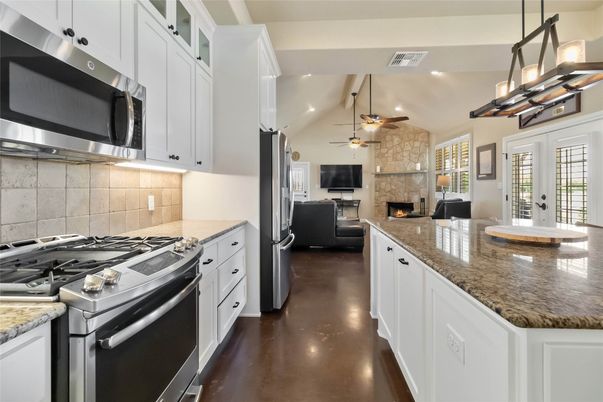 Fireplace, Interior, Kitchen, Living room, Pendant Lights, Recessed Lighting, Stainless Steel Appliances, Stone Walls, Wood Texture Flooring