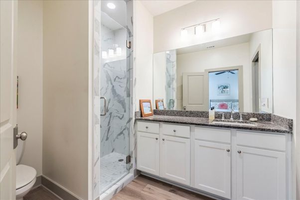 Bathroom, Dual Sink Vanities, Glass Shower, Interior, Marble Walls, Recessed Lighting, Wood Texture Flooring