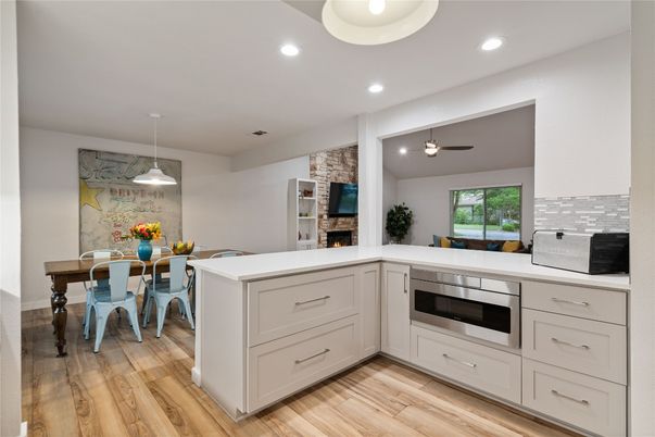 Dining room, Fireplace, Interior, Kitchen, Pendant Lights, Recessed Lighting, Stainless Steel Appliances, Stone Walls, Wood Texture Flooring