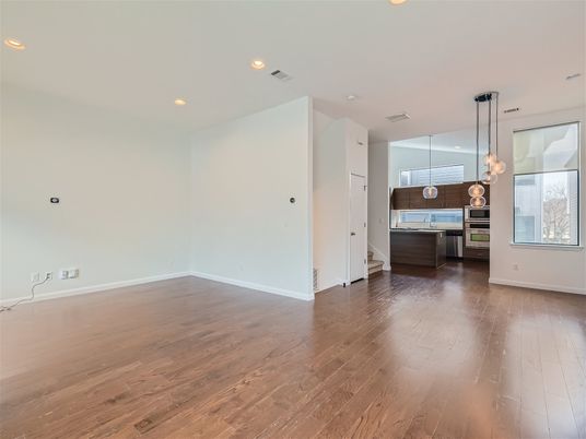 Empty room, Interior, Kitchen, Pendant Lights, Recessed Lighting, Stainless Steel Appliances, Wood Texture Flooring