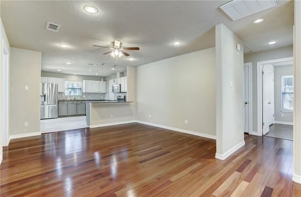 Empty room, Interior, Kitchen, Recessed Lighting, Stainless Steel Appliances, Wood Texture Flooring