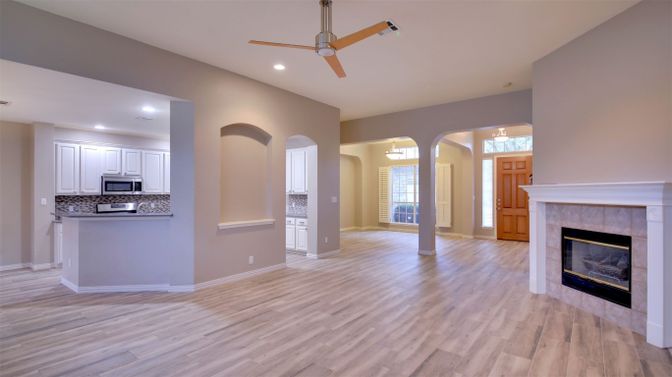 Empty room, Fireplace, Interior, Kitchen, Recessed Lighting, Stainless Steel Appliances, Wood Texture Flooring