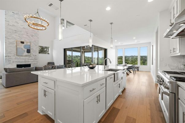 Chandelier, Fireplace, Interior, Kitchen, Pendant Lights, Recessed Lighting, Stainless Steel Appliances, Stone Walls, Wood Texture Flooring