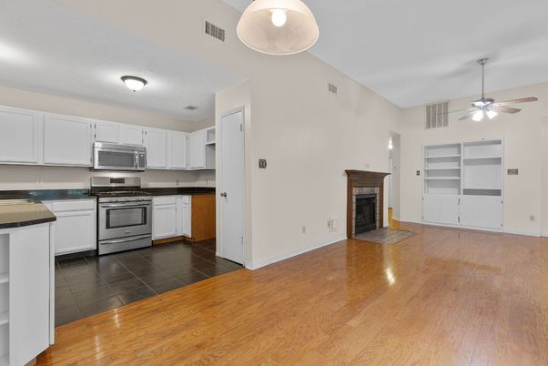 Empty room, Fireplace, Interior, Kitchen, Stainless Steel Appliances, Wood Texture Flooring