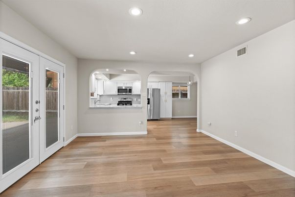 Empty room, Interior, Kitchen, Recessed Lighting, Stainless Steel Appliances, Wood Texture Flooring