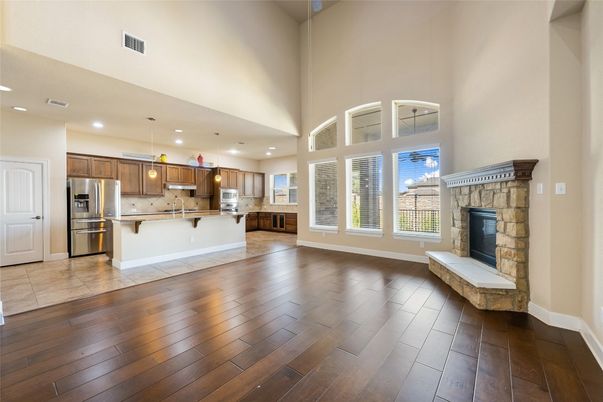 Empty room, Fireplace, Interior, Kitchen, Pendant Lights, Recessed Lighting, Stainless Steel Appliances, Wood Texture Flooring