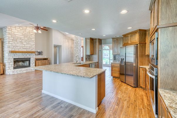 Fireplace, Interior, Kitchen, Recessed Lighting, Stainless Steel Appliances, Stone Walls, Wood Texture Flooring