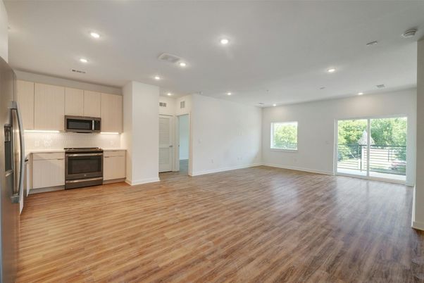 Empty room, Interior, Kitchen, Recessed Lighting, Stainless Steel Appliances, Wood Texture Flooring