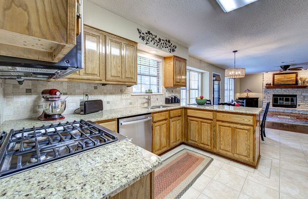 Chandelier, Fireplace, Interior, Kitchen, Pendant Lights, Stainless Steel Appliances, Stone Walls
