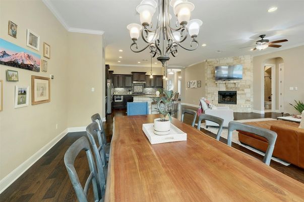 Chandelier, Dining room, Fireplace, Interior, Kitchen, Recessed Lighting, Stainless Steel Appliances, Stone Walls, Wood Texture Flooring