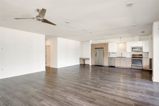 Empty room, Interior, Kitchen, Pendant Lights, Recessed Lighting, Stainless Steel Appliances, Wood Texture Flooring
