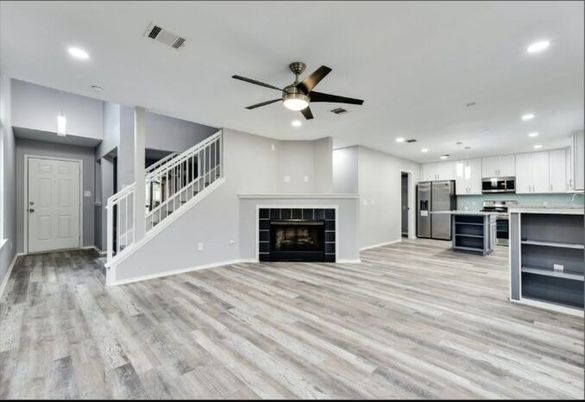 Empty room, Fireplace, Interior, Kitchen, Pendant Lights, Recessed Lighting, Stainless Steel Appliances, Wood Texture Flooring