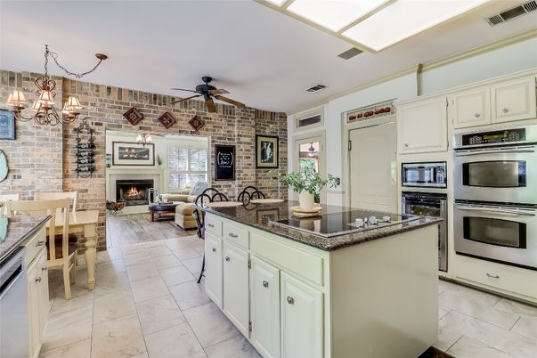 Chandelier, Dining room, Fireplace, Interior, Kitchen, Living room, Pendant Lights, Stainless Steel Appliances, Stone Walls
