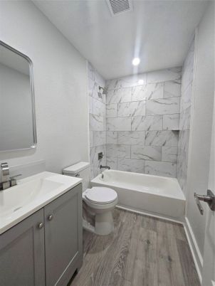 Bathroom, Dual Sink Vanities, Interior, Marble Walls, Recessed Lighting, Wood Texture Flooring