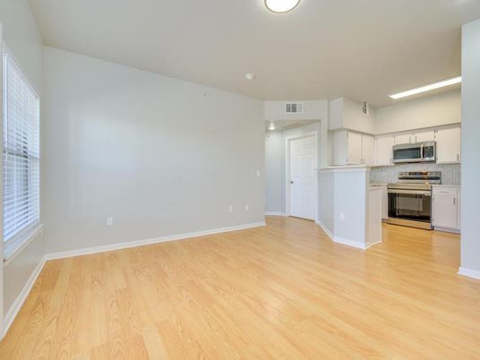 Empty room, Interior, Kitchen, Recessed Lighting, Stainless Steel Appliances, Wood Texture Flooring