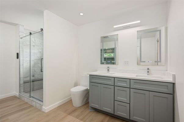 Bathroom, Dual Sink Vanities, Glass Shower, Interior, Marble Walls, Recessed Lighting, Wood Texture Flooring