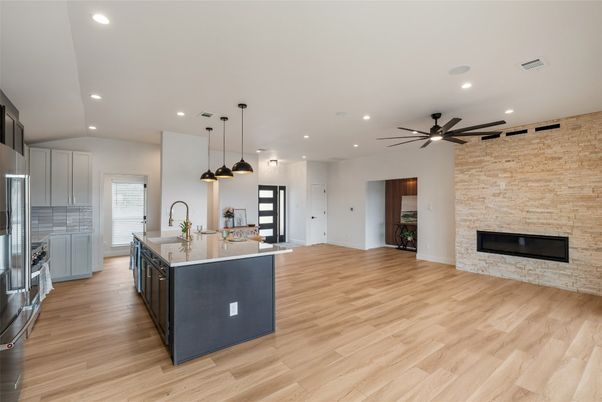Fireplace, Interior, Kitchen, Pendant Lights, Recessed Lighting, Stainless Steel Appliances, Stone Walls, Wood Texture Flooring
