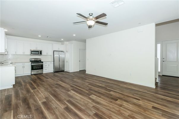 Empty room, Interior, Kitchen, Recessed Lighting, Stainless Steel Appliances, Wood Texture Flooring