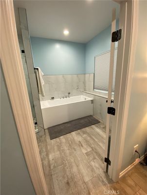 Bathroom, Free Standing Baths, Interior, Marble Walls, Recessed Lighting, Wood Texture Flooring