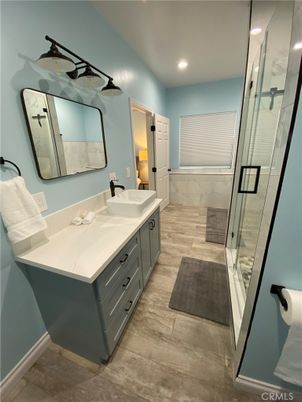 Bathroom, Dual Sink Vanities, Glass Shower, Interior, Marble Walls, Recessed Lighting, Wood Texture Flooring