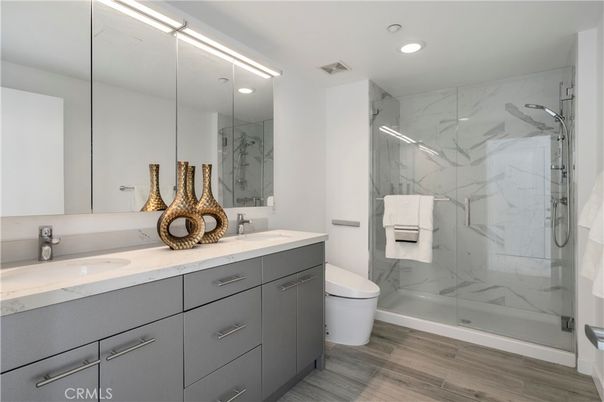 Bathroom, Dual Sink Vanities, Glass Shower, Interior, Marble Walls, Recessed Lighting, Wood Texture Flooring