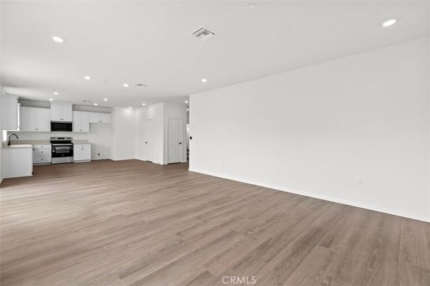 Empty room, Interior, Kitchen, Recessed Lighting, Stainless Steel Appliances, Wood Texture Flooring