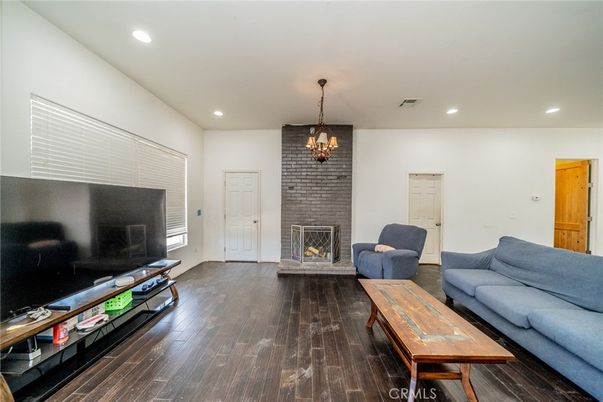 Chandelier, Fireplace, Interior, Living room, Recessed Lighting, Stone Walls, Wood Texture Flooring