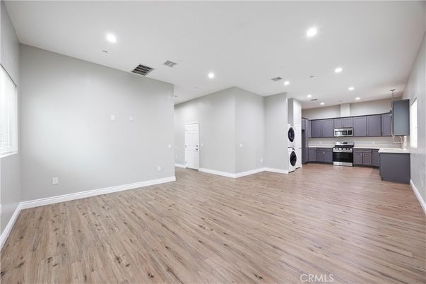 Empty room, Interior, Kitchen, Recessed Lighting, Stainless Steel Appliances, Wood Texture Flooring