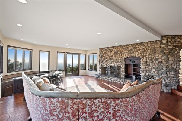 Fireplace, Game Room, Interior, Living room, Piano, Recessed Lighting, Stone Walls, Wood Texture Flooring