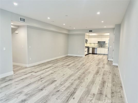 Empty room, Interior, Kitchen, Recessed Lighting, Stainless Steel Appliances, Wood Texture Flooring