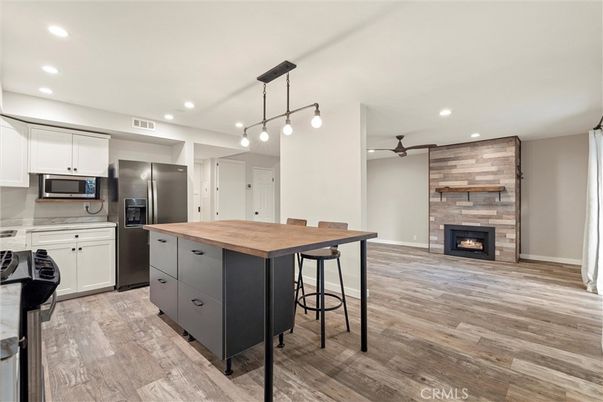 Fireplace, Interior, Kitchen, Pendant Lights, Recessed Lighting, Stainless Steel Appliances, Stone Walls, Wood Texture Flooring