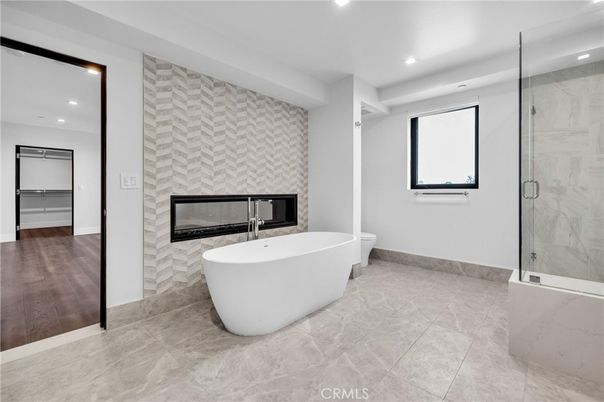 Bathroom, Fireplace, Free Standing Baths, Glass Shower, Interior, Marble Walls, Recessed Lighting, Wood Texture Flooring