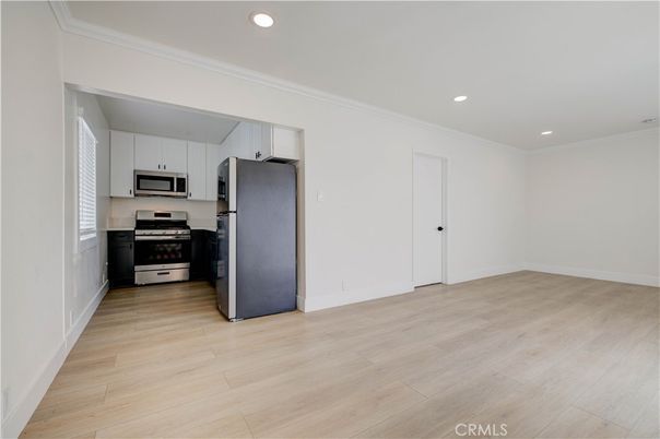 Empty room, Interior, Kitchen, Recessed Lighting, Stainless Steel Appliances, Wood Texture Flooring