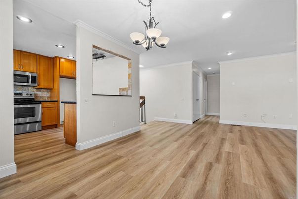 Chandelier, Empty room, Interior, Kitchen, Pendant Lights, Recessed Lighting, Stainless Steel Appliances, Wood Texture Flooring