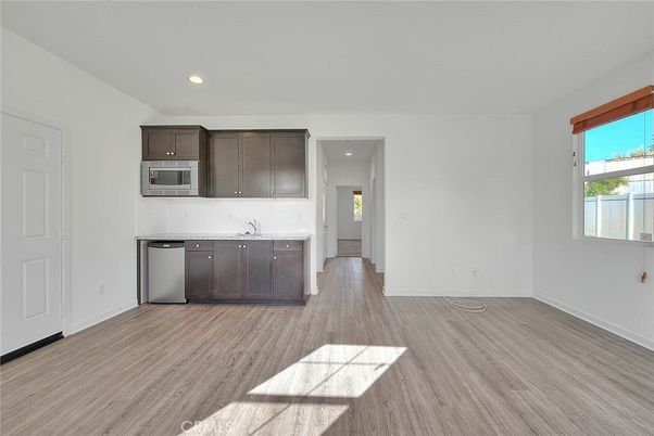 Empty room, Interior, Kitchen, Recessed Lighting, Stainless Steel Appliances, Wood Texture Flooring