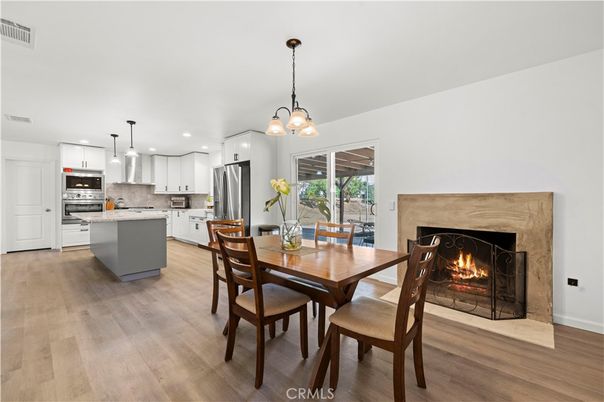 Chandelier, Dining room, Fireplace, Interior, Kitchen, Pendant Lights, Recessed Lighting, Stainless Steel Appliances, Wood Texture Flooring