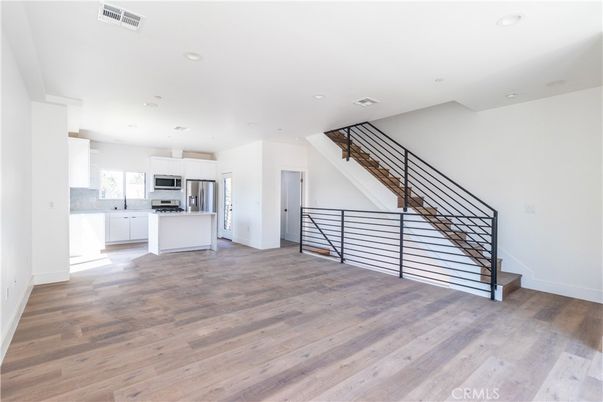 Empty room, Interior, Kitchen, Recessed Lighting, Stainless Steel Appliances, Wood Texture Flooring