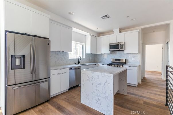 Interior, Kitchen, Marble Walls, Recessed Lighting, Stainless Steel Appliances, Wood Texture Flooring