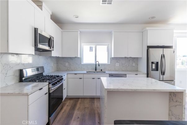 Interior, Kitchen, Marble Walls, Recessed Lighting, Stainless Steel Appliances, Wood Texture Flooring