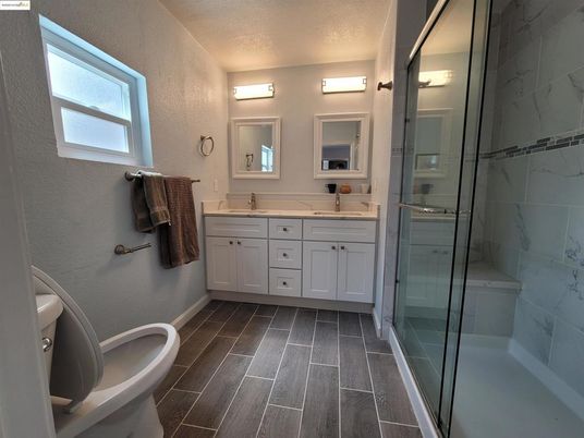 Bathroom, Dual Sink Vanities, Glass Shower, Interior, Marble Walls, Wood Texture Flooring