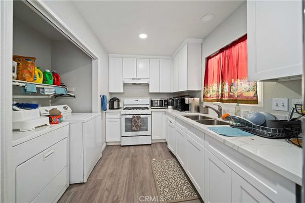 Interior, Kitchen, Recessed Lighting, Tile Countertops, Washer, Wood Texture Flooring