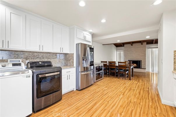 Dining room, Fireplace, Interior, Kitchen, Recessed Lighting, Stainless Steel Appliances, Stone Walls, Washer, Wood Texture Flooring
