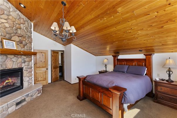Bedroom, Chandelier, Fireplace, Interior, Recessed Lighting, Stone Walls, Wooden Ceilings