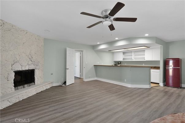 Empty room, Fireplace, Interior, Kitchen, Recessed Lighting, Stone Walls, Wood Texture Flooring